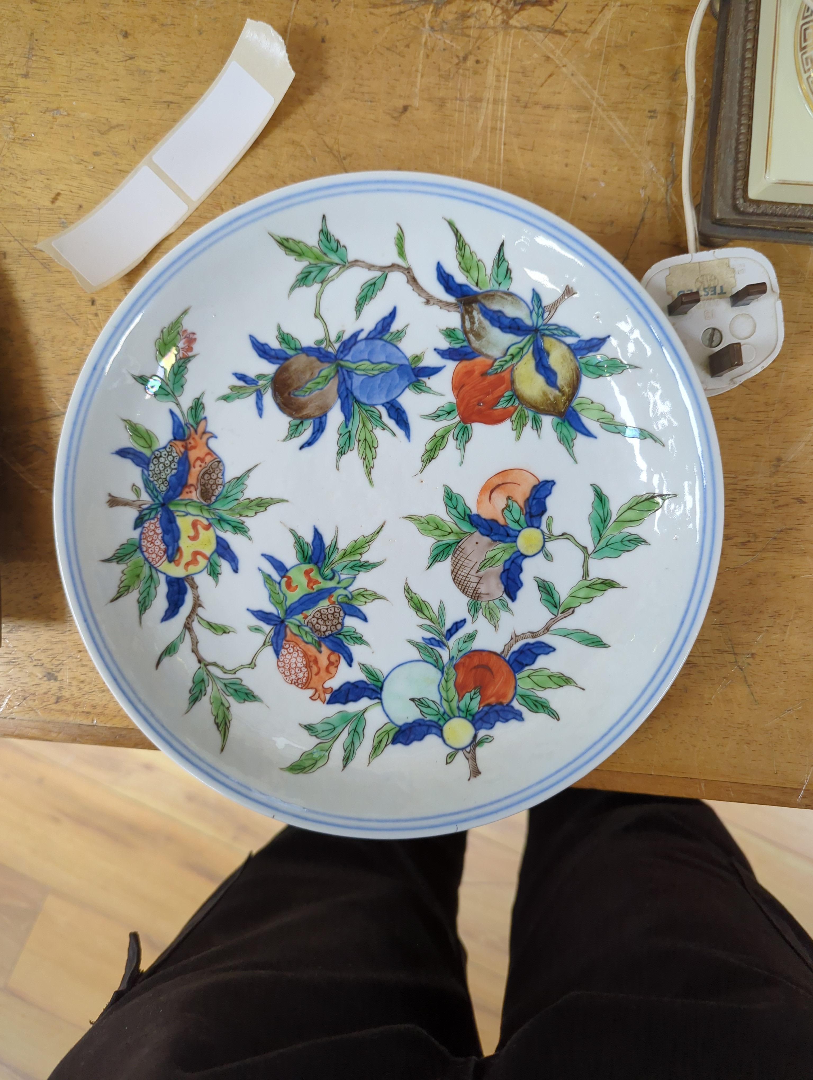 An 18th century Chinese famille rose bowl and a group of five Chinese wucai plates, each decorated with fruit, the bowl 23cm in diameter